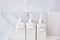 Toiletries bottles in bathroom at luxury hotel or modern home. White shower container set, body shower gel, shampoo and hair