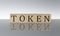 TOKEN concept, wooden word block on the grey background