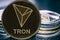 Token cryptocurrency Tron TRX on the background of a stack of coins.