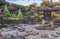 Tokyo Metropolitan Park KyuFurukawa japanese garden`s Yukimi stone lantern overlooking by red maple momiji leaves in autumn