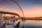 Tolerance bridge and promenade embankment along Dubai Creek Canal during majestic colorful sunset