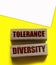 Tolerance diversity words on wooden blocks on yellow. Equality concept by gender, ethnicity and age