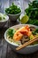 Tom Kha goong soup - coconut shrimp soup with noodles and shiitake mushrooms on wooden table