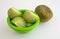 Tomatillos cut in a bowl on a white cutting board