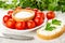 Tomato cherry, bowl with salt in saucer, knife, sandwich with melted cheese, parsley on wooden table