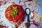 Tomato chutney or Indian styled tomato ketchup in a glass plate along with its spices and ingredients on wooden surface.