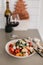 Tomato crostini salad with mozzarella cheese. Refreshing healthy dinner. Glass of red wine. Nourishing salad lunch. Panzanella