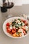 Tomato crostini salad with mozzarella cheese. Refreshing healthy dinner. Glass of red wine. Nourishing salad lunch. Panzanella