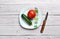 Tomato, cucumber, plate and knife isolated on an old wooden white rustic table