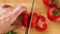 Tomato cutting closeup. Chef slices the cherry tomato. Cut vegetables for salad. Healthy food. Top view.