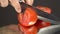 Tomato cutting closeup. On a dark mirror background