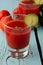 Tomato gazpacho in glasses over blue wooden table