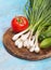 tomato, green onions and cucumbers on a wooden shabby blue background. Selective focus