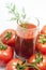 Tomato juice in a glass with dill sprig.