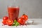 Tomato juice in a glass with falling salt , fresh tomatoes, basil and pepper