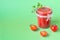 Tomato juice with a leaf of parsley in a glass jar and fresh tomatoes. Light green background. copy space
