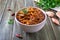 Tomato lobio of green bean pods in a bowl on a wooden background. Lenten dish