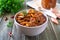 Tomato lobio of green bean pods in a bowl on a wooden background. Lenten dish