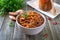 Tomato lobio of green bean pods in a bowl on a wooden background. Lenten dish