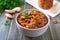 Tomato lobio of green bean pods in a bowl on a wooden background.   Lenten dish