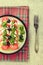 Tomato and mozzarella caprese salad and pesto sauce with olives on gray table