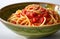 tomato paste on spaghetti in green ceramic bowl in white