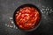 Tomato sauce in a bowl at black stone table.