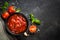 Tomato sauce in a bowl with spices and fresh tomatoes.