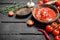 Tomato sauce in bowl with spoon, herbs and pepper