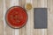 Tomato sauce in clear bowl with oregano spice on weathered wood background