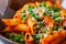 Tomato sauce and green peas penne pasta in a plate on a white st