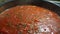 Tomato sauce with herbs boils, steam over the dish and bubbles, cooking tomato sauce.