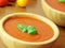 Tomato soup with basil herb. Wooden background. Close up view.