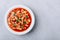 Tomato soup. Minestrone soup. Tomato bean and pasta soup bowl on gray stone background