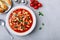 Tomato soup. Minestrone soup. Tomato bean and pasta soup bowl with toasts on gray stone background