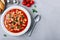 Tomato soup. Minestrone soup. Tomato bean and pasta soup bowl with toasts on gray stone background