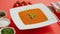 Tomato soup in plate with green leaf