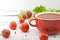 Tomato soup in red ceramic bowl on rustic wooden background. Hea