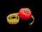 Tomato and tape measure over black