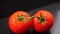 Tomato with water drops on black table. Shot by panning the camera