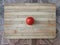 Tomato on a wooden surface. Fresh tomato on a cutting board. Tomato for salads, soups, pizza and ketchup.