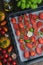 Tomatoes on baking sheet, aromatic herbs, thyme, basic, garlic, olive oil, top view