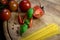 Tomatoes and basil with Spaghetti and pepper on a wooden plate