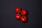 Tomatoes on a black background. Tomatoes on a vine on a dark background.