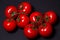 Tomatoes on a black background. Tomatoes on a vine on a dark background.