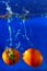 Tomatoes drop water spurting on background