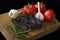 Tomatoes, garlic, dried deer meat, Bay leaves and allspice on a wooden Board. black background. isolate