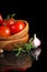 Tomatoes and garlic in wooden plate on black backg