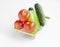 Tomatoes, green bell pepper and cucumbers in a small metal grocery basket