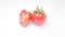 Tomatoes in greenery over white background